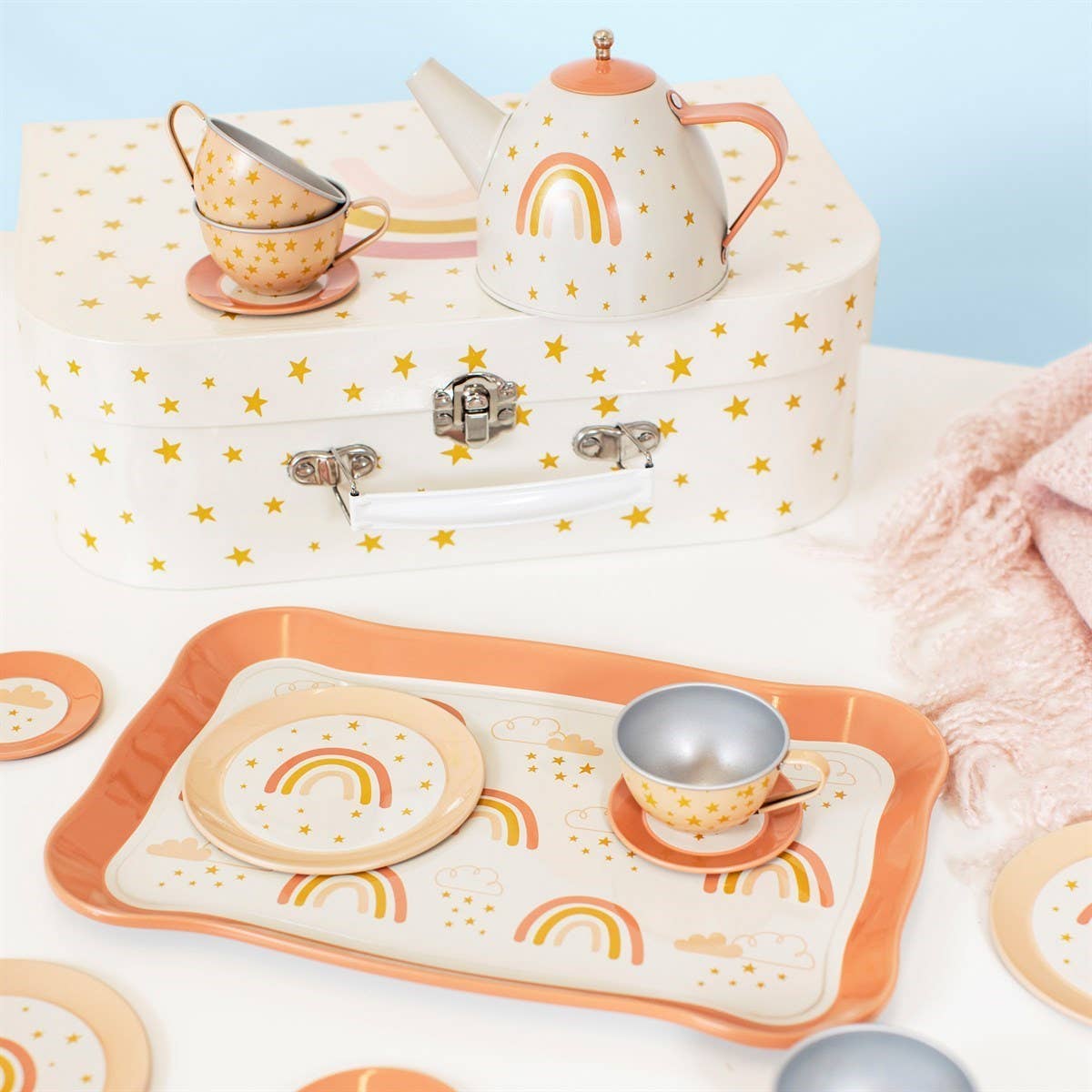 Children's tea set with rainbow design on a white surface
