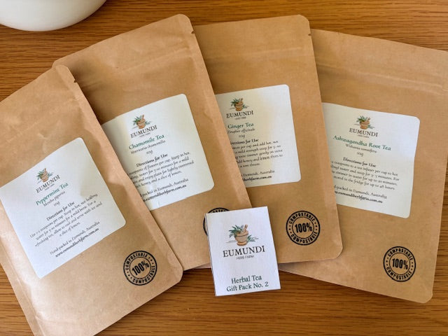 Eumundi_Herb_farm_Tea Gift_packs with labels on a wooden surface