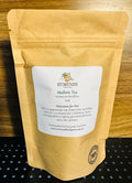 Yellow tea package with a label on a wooden surface