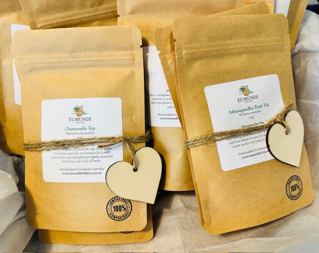 Tea packages with labels and heart-shaped tags on a wooden surface