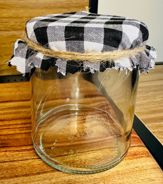 Clear glass jar with a black and white checkered lid on a wooden surface