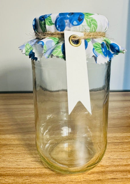Clear glass jar with floral-patterned lid on a wooden surface