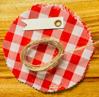 Red and white checkered paper with a string and small tag on a wooden surface