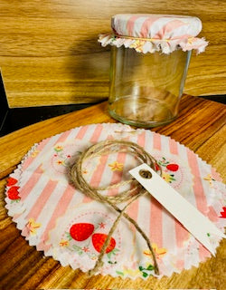 Decorative glass jar with a floral lid on a wooden surface