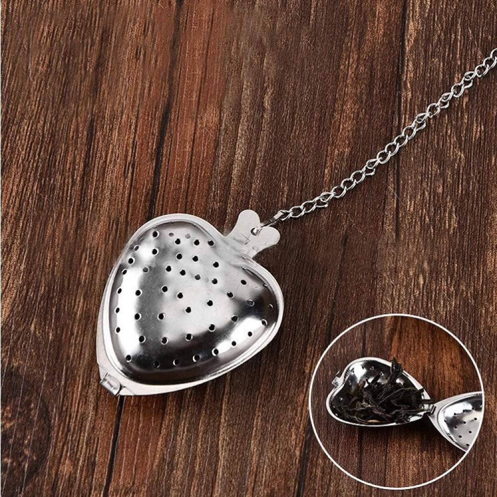 Heart-shaped metal tea infuser on a wooden surface with an inset showing tea leaves.