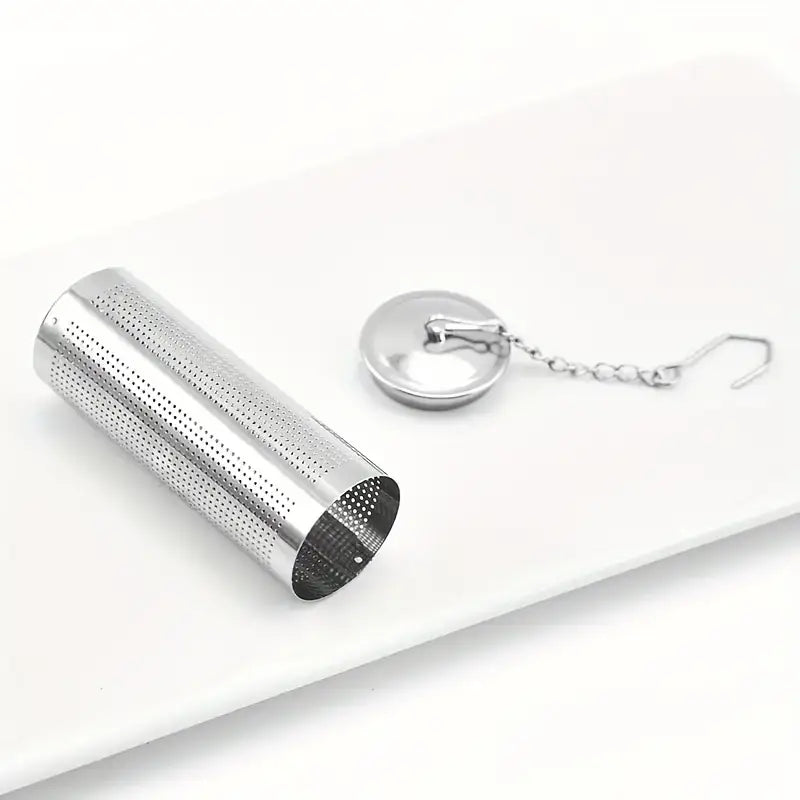 Silver metal tea infuser with chain on a white background